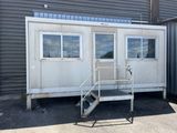 a small white building with a ramp next to it