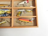 many different types of fishing lures in a wooden box
