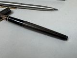 two pens and a lighter sitting on a table