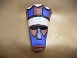 a blue and red mask on a brown leather surface