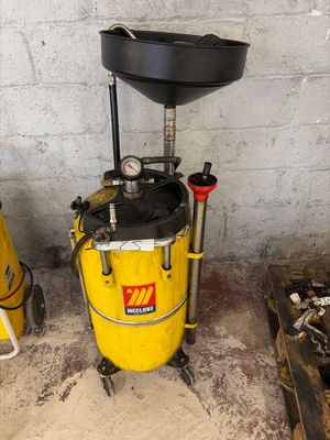 a yellow bucket with a black lid sitting next to a yellow bucket with a black lid