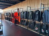 many jackets and pants hanging on the wall in the store