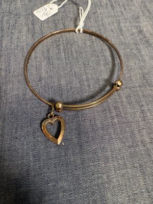 un gros plan d'un bracelet orné d'une breloque en forme de cœur