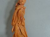 an orange statue of a woman holding a torch in her hand