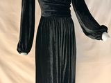 une robe en velours noir à manches longues posée sur un mannequin
