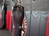 three punching bags hanging on the wall in the gym
