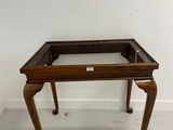 an old wooden table with a glass top and legs