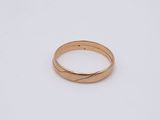 gros plan d'une bague en or sur une surface blanche