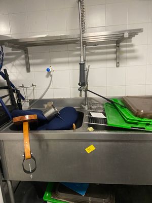 un évier de cuisine sur lequel s'entassent de nombreux objets