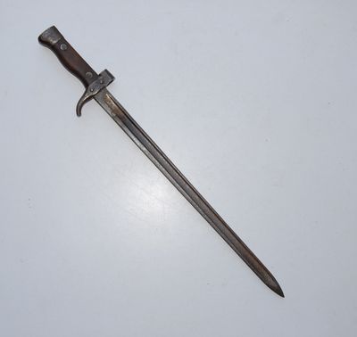 an old sword with a wooden handle on a white surface