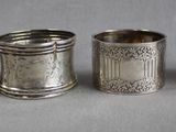 four silver napkins with designs on them sitting on a table