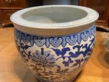 a blue and white vase sitting on a wooden table