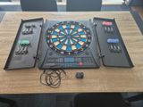 a table with a dart board and other electronic gadgets on it