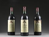 three bottles of wine sit side by side on a table