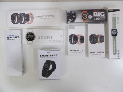 several smart watches are displayed on a white surface in a store