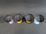 four metal cups sitting on top of a table next to each other