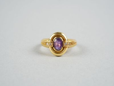 gros plan d'une bague en or avec une pierre violette