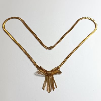 gros plan d'un collier en or auquel est attachée une chaîne