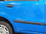 a small blue car parked on the side of the street