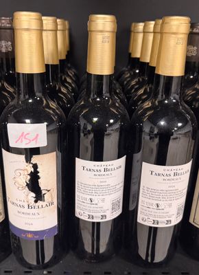 several bottles of wine are lined up on a shelf in a store