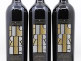 trois bouteilles de vin posées les unes à côté des autres sur une surface blanche