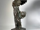 statue of a woman holding a bird on a marble base