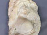 une statue représentant une femme assise sur un rocher