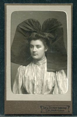 une vieille photo d'une femme portant un grand chapeau sur la tête