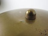 a close up view of a brass bell on a white table