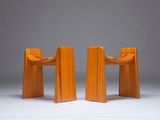 two wooden chairs sitting next to each other on a white surface
