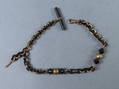 un gros plan d'un bracelet à maillons orné d'une croix