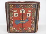a red and blue rug with a bird on top of it