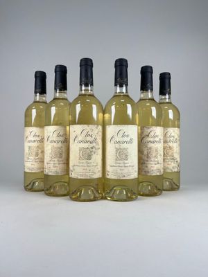 four bottles of white wine are lined up in a row