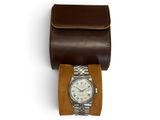brown leather watch case with a watch inside of it on a white surface