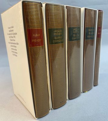 four books are lined up in a row on a white surface