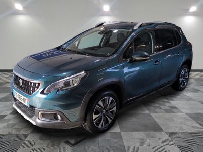 le 4x4 bleu est garé sur le sol en damier d'un garage