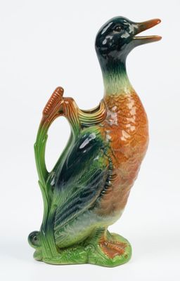 un canard en céramique perché sur une plante