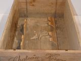 a wooden box that has a bottle of wine inside of it