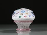 une image représentant un objet en forme de cupcake blanc et rose posé sur une surface réfléchissante