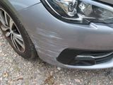 a close up of a car ' s front bumper with a denting on it