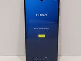 l'arrière d'un téléphone noir doté d'un écran bleu, posé sur une surface blanche