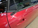 a red car that has a sticker on the side of it