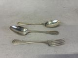 three spoons and a fork sitting on a table