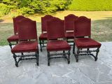 quatre chaises en velours rouge disposées sur une terrasse en pierre