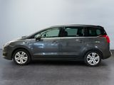the grey minivan is parked in a room with a gray floor