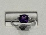 une bague sertie d'une pierre violette, dans un écrin