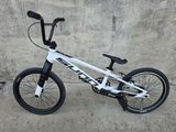 un vélo blanc garé sur le trottoir