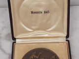 une petite boîte contenant une médaille, posée sur une surface en marbre