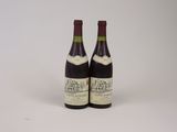 deux bouteilles de vin posées l'une à côté de l'autre sur une surface blanche