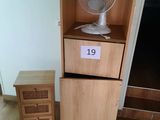a fan that is sitting on top of a wooden cabinet